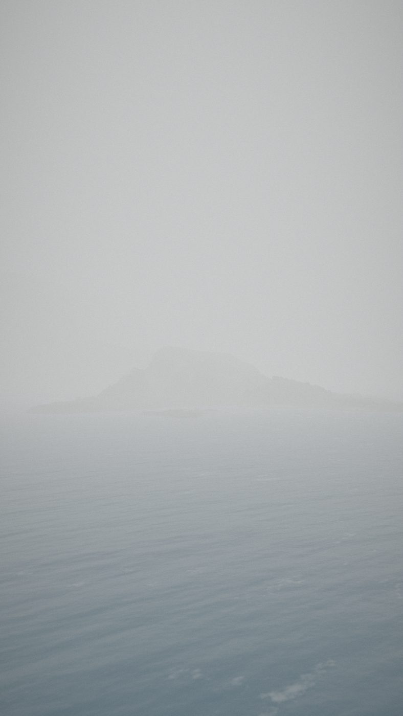 A 3D view of Cape d'Or in thick grey fog: the cliffs are a faint shape and the sea a flat grey.